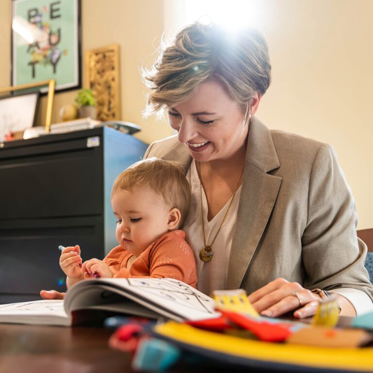 Happy mother reading a childrens book to her baby